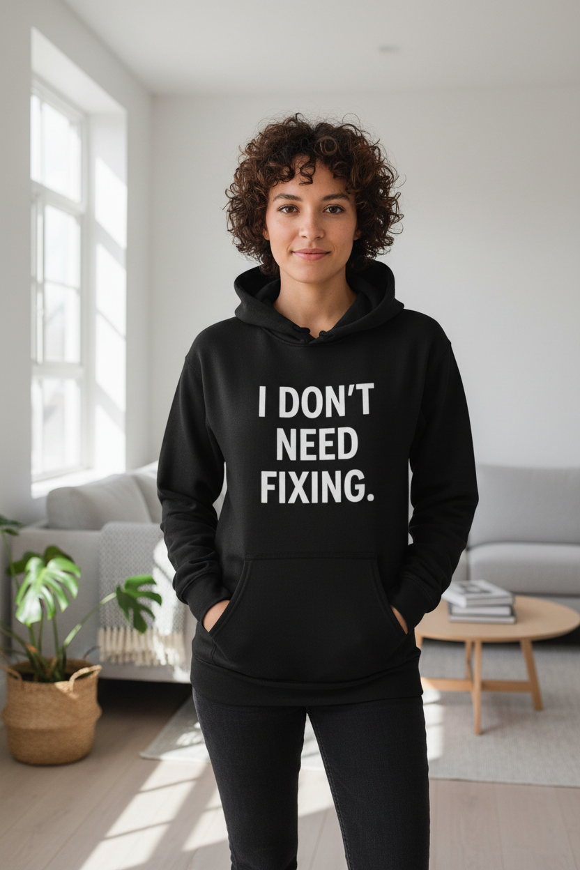 Woman wearing I Don't Need Fixing black neurodivergent hoodie indoors