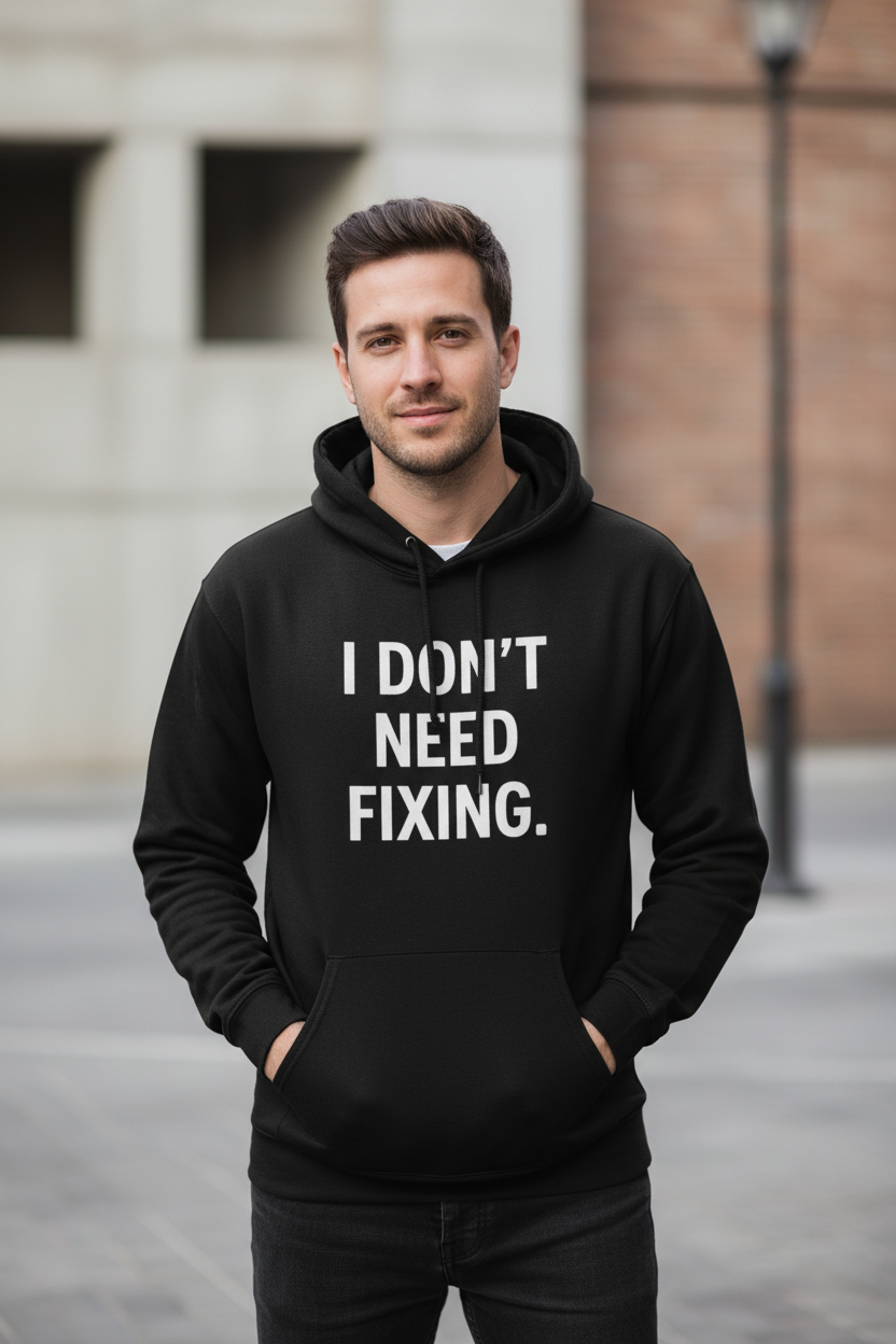 Man outdoors wearing I Don't Need Fixing black neurodivergent hoodie