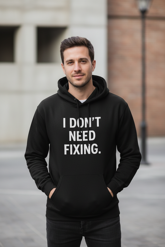 Man outdoors wearing I Don't Need Fixing black neurodivergent hoodie